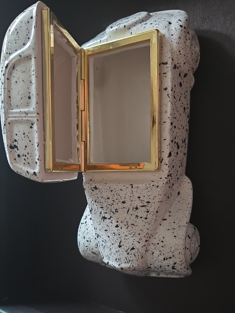 A speckled white and black ceramic jewelry box with a gold accent